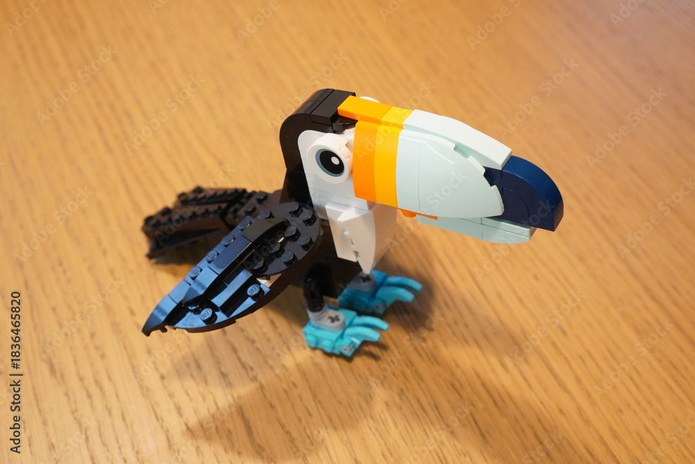 Obraz premium A colorful Lego toucan bird model on a wooden surface