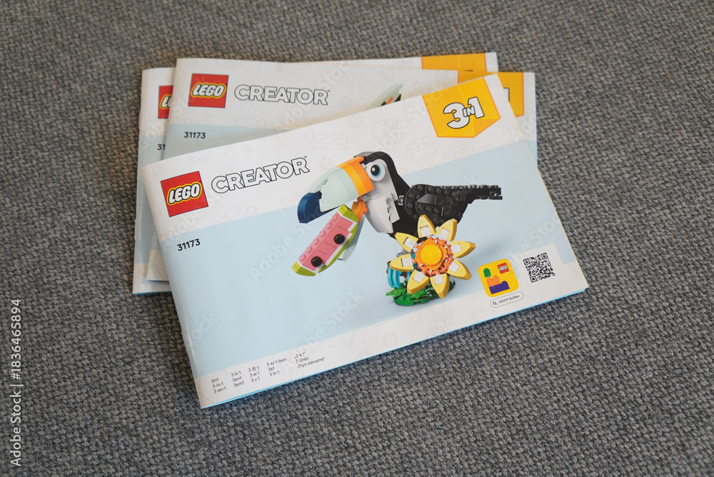 Obraz premium Lego Creator 3-in-1 Toucan Building Set Instruction Manuals on a Gray Surface