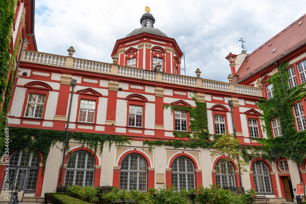 Obraz premium Historic red and white baroque building with ivy-covered walls. Ossoliński National Institute
