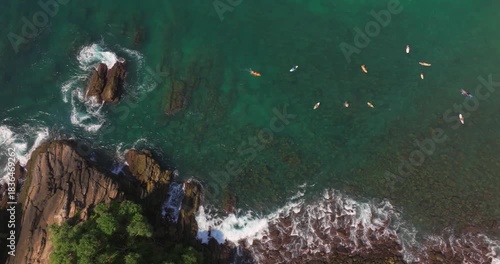 Aerial View of Surfers Near a Rocky Tropical Coastline with Palm Trees and Turquoise Ocean at Hiriketiya, Sri Lanka