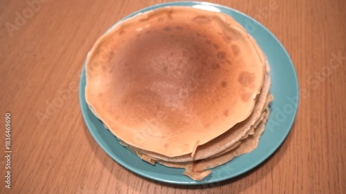 Stack of delicious pancakes on a blue plate, ready to be served for breakfast