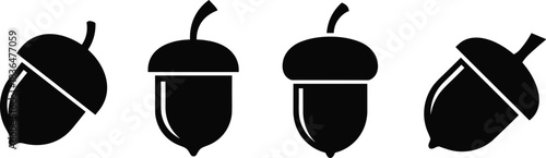 Four black silhouette acorns with caps on white background vector