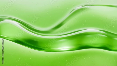 Close-up of a vibrant green translucent liquid with smooth, flowing waves and reflections.