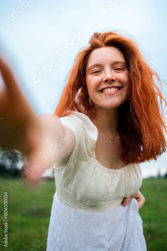 Joyful young woman smiling outdoors in a bright summer scene