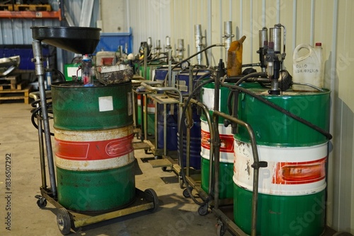 Barrels of hydraulic and mechanical oils are arranged along the wall of the garage. Each barrel is equipped with a metering pump for easy oil extraction. The barrels are mounted on mobile carts.