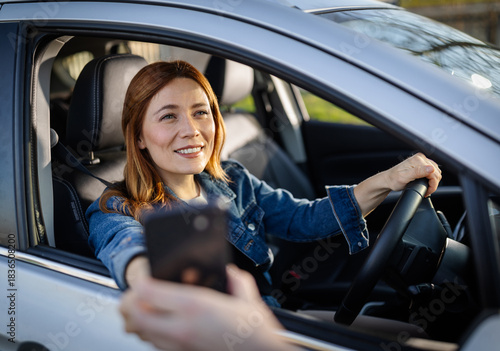 Woman in car pays at drive-thru window