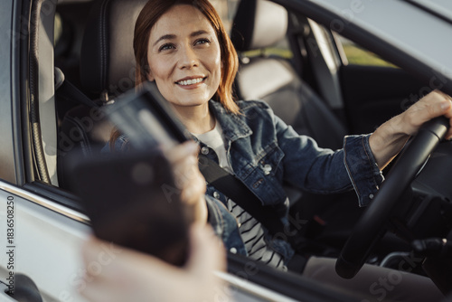 Obraz na plátne Woman in car pays at drive-thru window