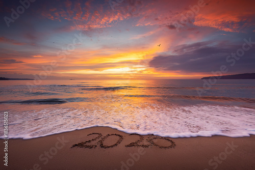 Fototapeta Naklejka Na Ścianę i Meble -  tropical beach and sunrise over the sea shore with splashed waves in the sand, ocean sunset landscape 2026 text ont he sea sand