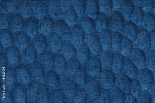 Textured blue wooden surface with carved oval patterns and visible wood grain. Abstract texture background ideal for design, craft, or natural texture themes.