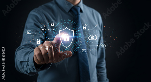 Businessman touching digital shield icon representing cybersecurity and data protection in a modern technology driven business environment