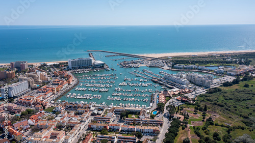 Wallpaper Mural People enjoy the sunny weather while overlooking the large marina filled with boats in Vilamoura, a popular tourism spot in Portugal's Algarve region Aerial Torontodigital.ca