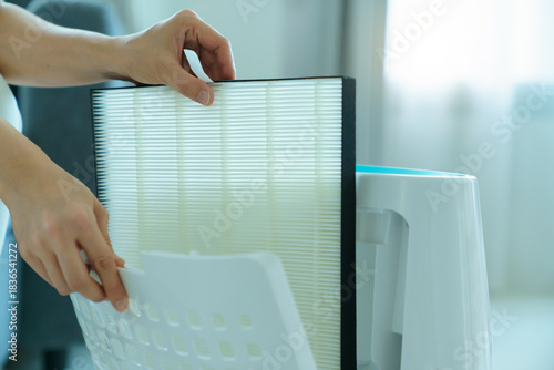 Fotografi Close up view of hands installing HEPA air purifier filter, demonstrating essential maintenance for improving indoor air quality