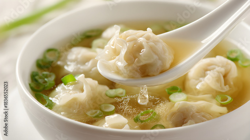 Wonton soup serving with spoon of delicious dumplings