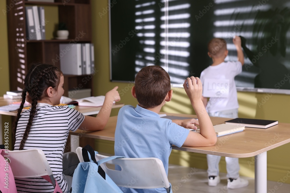 Obraz premium Boy getting bullying by classmates in classroom, selective focus