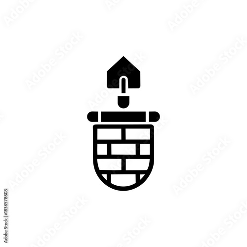 A solid black icon featuring a construction trowel inserted into a rounded brick structure, symbolizing building, masonry, or well digging.