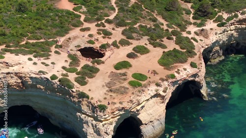 Aerial view of boats and kayaks approaching the Benagil Cave during summer, Algarve region, southern Portugal.