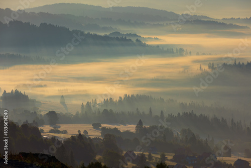 Fototapeta Naklejka Na Ścianę i Meble -  Autumn mountain view and peaceful landscape with fog and sunlight at dawn, Beskid, Poland, natural background or nature photo wallpaper