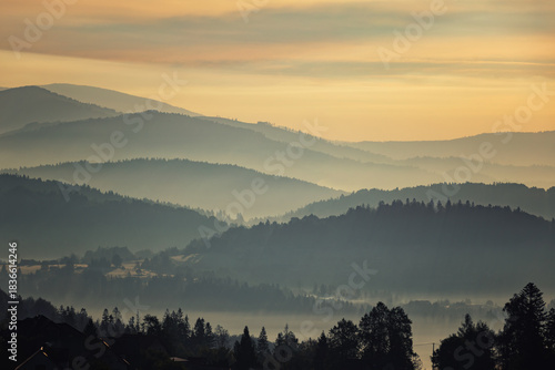 Fototapeta Naklejka Na Ścianę i Meble -  Autumn mountain view and peaceful landscape with fog and sunlight at dawn, Beskid, Poland, natural background or nature photo wallpaper
