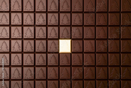 Festive creative chocolate background made of chocolate bars with a Christmas tree outline.