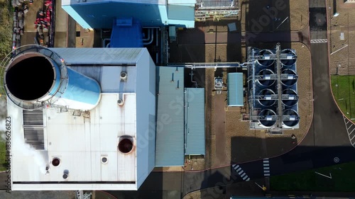 Top down aerial drone view of Power station, cooling fans and turbines, smoke chimney stack and plumes on sunny day in Kings Lynn, UK