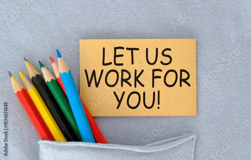 A pocket with a piece of paper that says Let Us Work For You. The paper is on top of a pencil case with a bunch of colored pencils