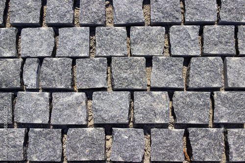 Paving the road with square granite stones.