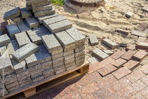 A stack of gray granite tiles on a pallet. Sidewalk repair work.