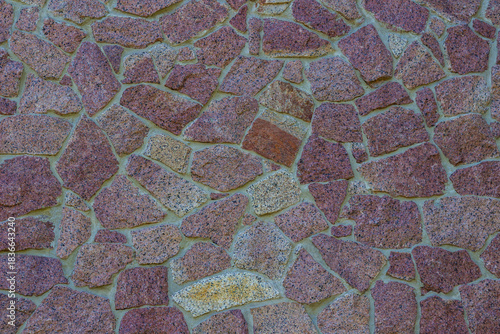 A wall lined with red granite tiles.