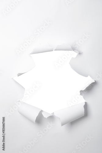 a sheet of paper with a torn hole in the middle in the form of a frame, isolated on a white background