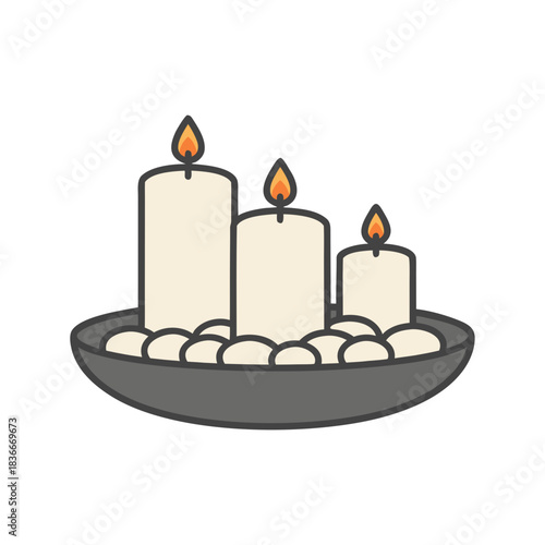 Three lit white pillar candles of varying heights in a grey bowl with smooth beige pebbles and warm flickering flames on a black background