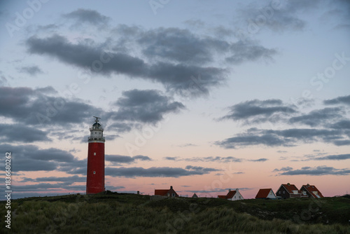 Red Lighthouse on Baltic Coast at Sunset Under Dramatic Cloudy Sky