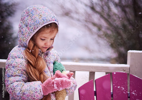 Winter Portrait of Little Girl Playing with Snow on a Snowy Day – Cozy Pastel Childhood Scene in Suburban Outdoors