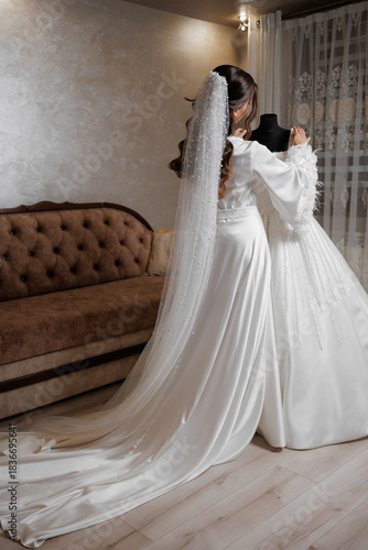 Bride in elegant wedding dress fitting joyful moment in stylish indoor setting