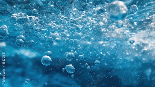 Bubbles can be seen rising in clear blue water with light reflecting off the surface. The scene captures the movement and energy of the underwater environment.