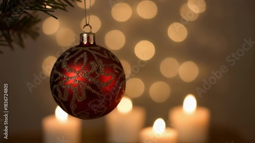 Red christmas ornament hanging with soft candlelight background