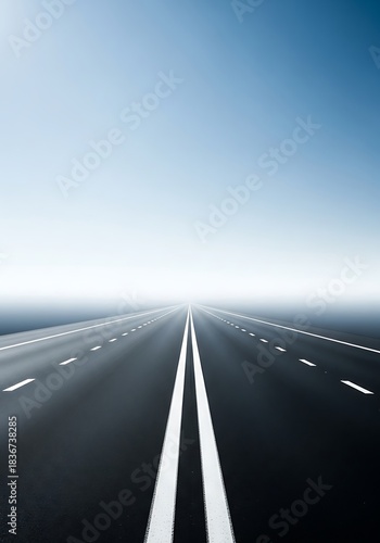 Endless asphalt road disappearing into the horizon under a hazy sky