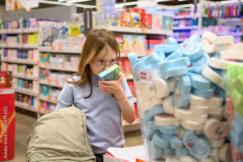 A girl chooses socks or pajamas with a Christmas print. Holiday shopping concept. Christmas gifts.