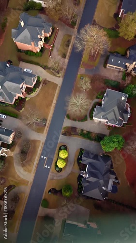 Vertical 4K aerial video of an upscale sub division in suburbs of USA shot early in the morning