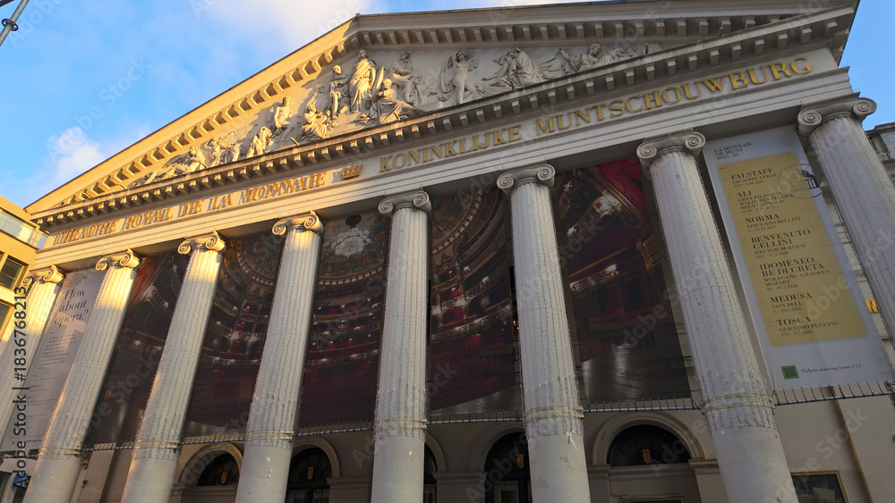 Naklejka premium BRUSSELS, BELGIUM - NOVEMBER 26, 2025 - La Monnaie opera house facade with neoclassical architecture and posters in Brussels, Belgium