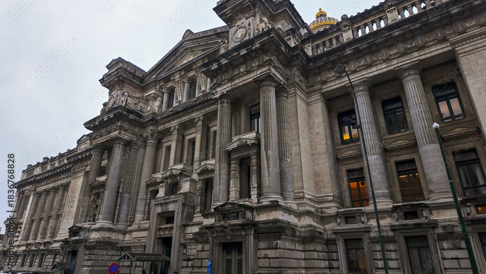 Naklejka premium BRUSSELS, BELGIUM - NOVEMBER 26, 2025 - Palace of Justice, a historic building featuring neoclassical architecture with columns and a golden dome