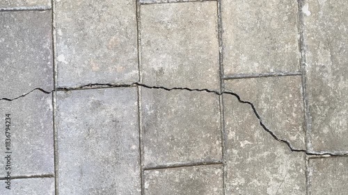 Long cracked concrete floor with a textured surface and a broken cement wall, perfect for a background.