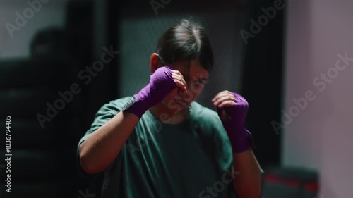 Determined young female boxer sparring at the gym