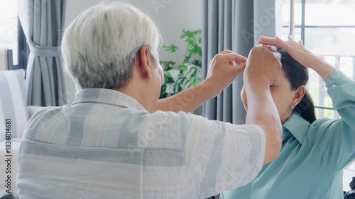 Old Asian senior elderly family couple grandparents man woman playing game. Mature grandmother grandfather spending time together play board game on couch at home