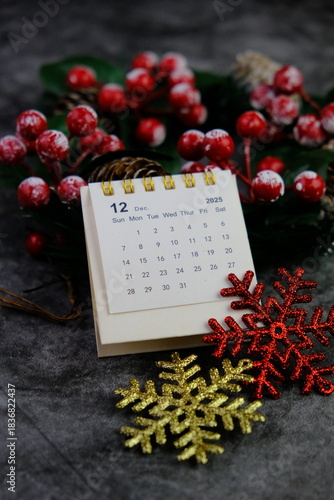 Season's greetings scene. Top view of Christmas decorations, balls, rustic star, holly berries, frosty spruce branches, confetti on green backdrop, perfect for messages or promo. text space concept