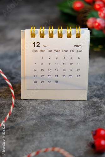 Season's greetings scene. Top view of Christmas decorations, balls, rustic star, holly berries, frosty spruce branches, confetti on green backdrop, perfect for messages or promo. text space concept