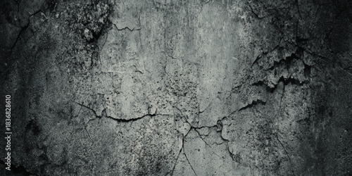 Dark grunge concrete wall texture background with cracks and distressed vintage ominous spooky atmosphere.