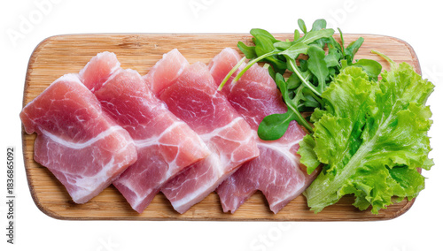 Sliced cured meat arranged with fresh greens on a wooden board
