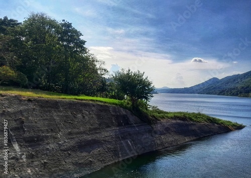 Scenic water reservoir view with concrete edge and hills.