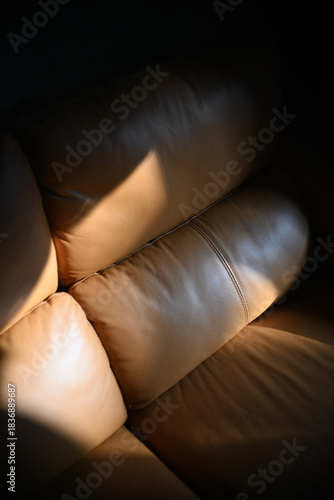 A relaxing brown leather sofa bathed in the evening sunlight.