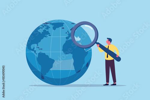 Global business expansion man with magnifying glass examining the world